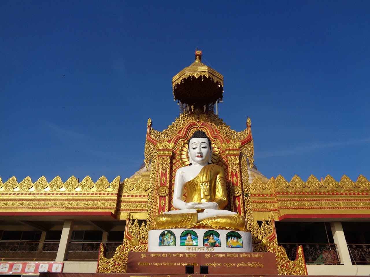 Magnificent golden Buddha statue at a decorated temple entrance in full daylight
